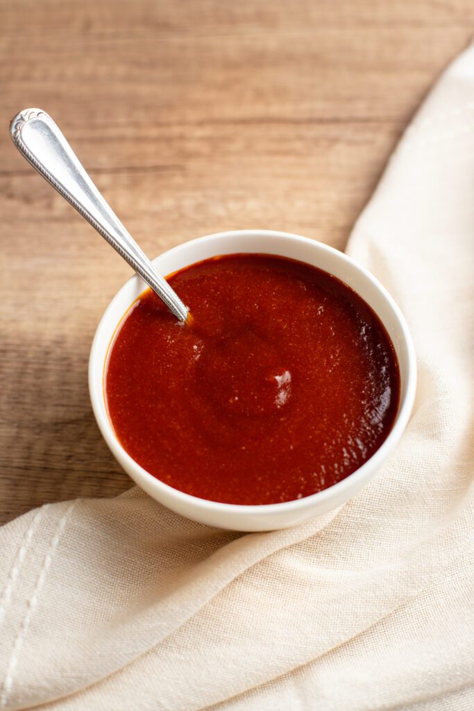 spoon in a bowl of sweet and tangy bbq sauce