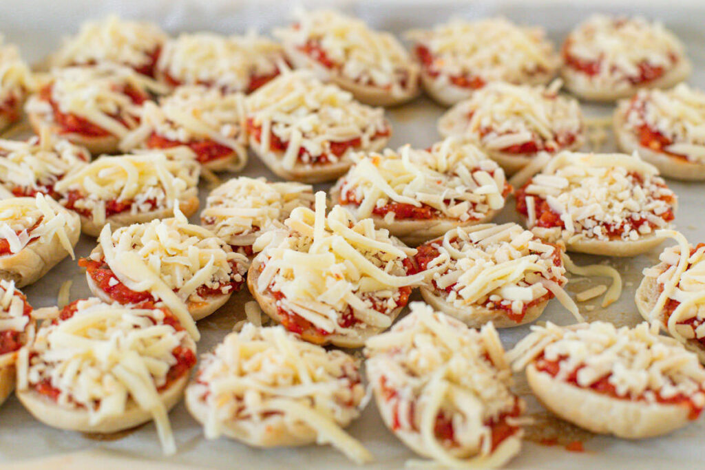 mini bagels with pizza sauce and shredded mozarella cheese