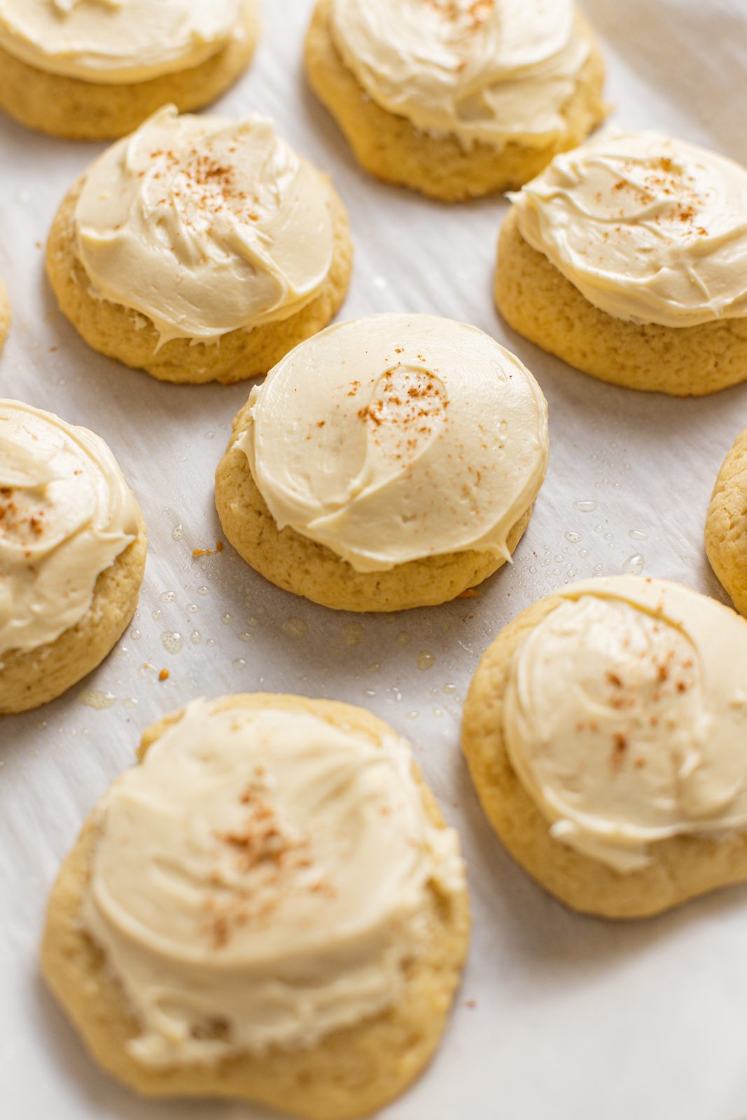 maple buttercream frosted sour cream cookies on baking sheet 