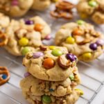 brown butter m&m pretzel cookies sitting on a cooling rack