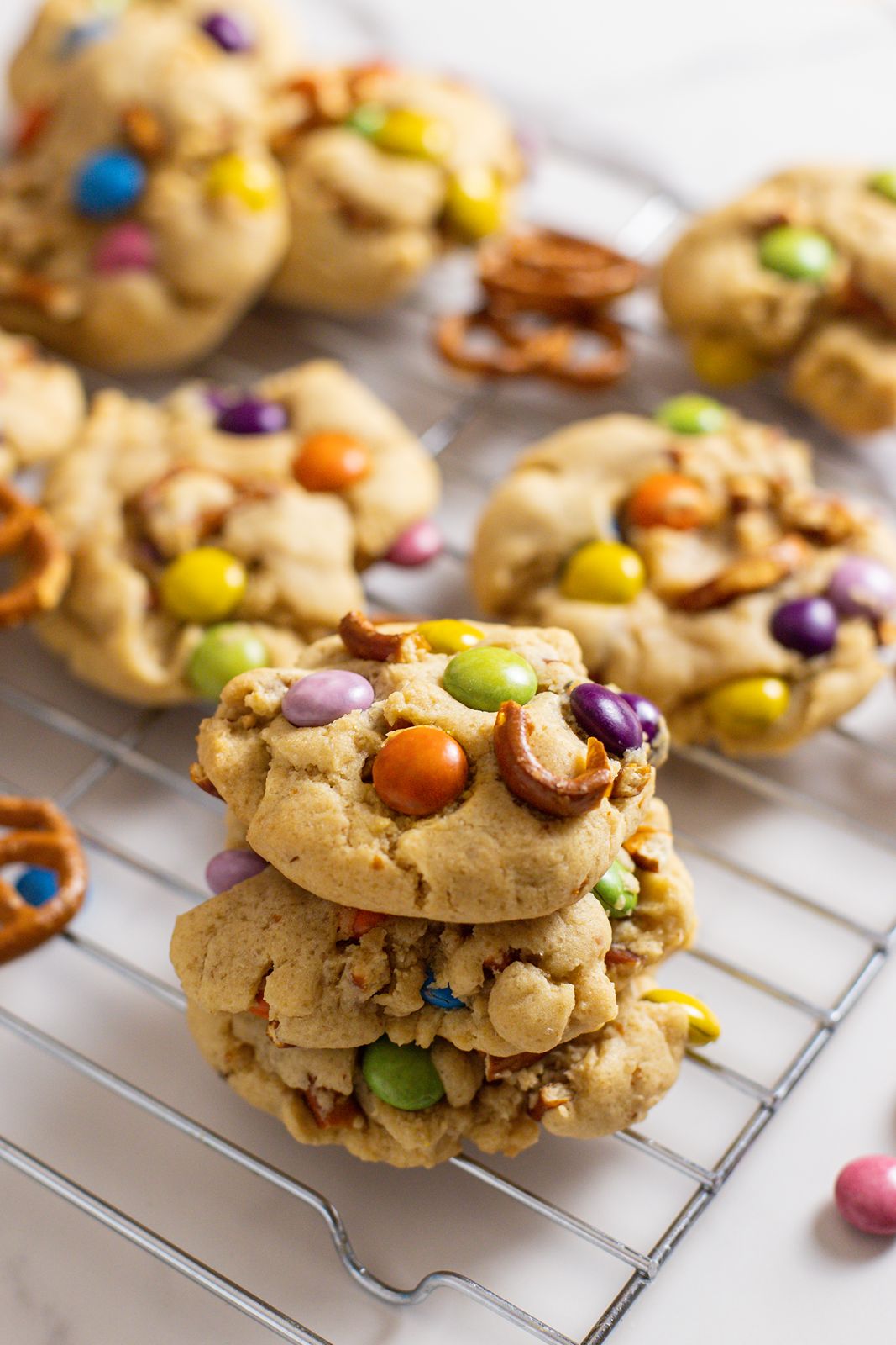 brown butter m&m pretzel cookies sitting on a cooling rack