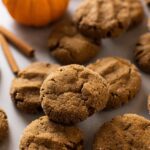 pumpkin molasses cookies on a baking sheet with a pumpkin