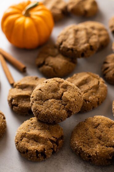 pumpkin molasses cookies on a baking sheet with a pumpkin