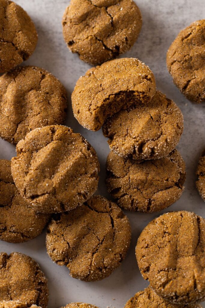 pumpkin molasses cookies piled up, one with a bite taken from it