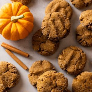 pumpkin molasses cookies on a baking sheet with a pumpkin