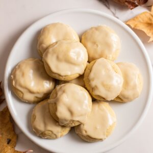 maple cookies with maple icing sitting on plate with maple leaves