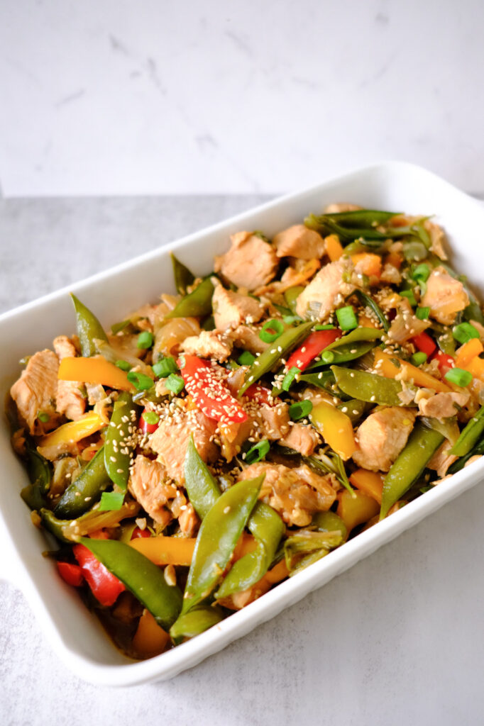 honey chicken stir fry in a white pan
