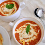 roasted tomato vegetable soup in bowls with a spoon