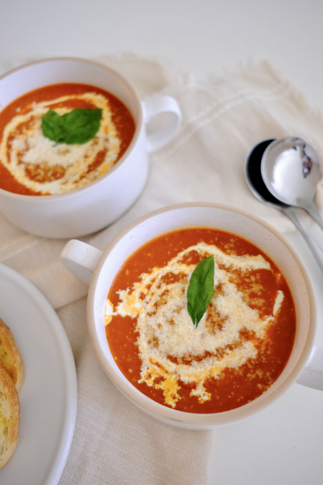 roasted tomato vegetable soup in bowls with a spoon