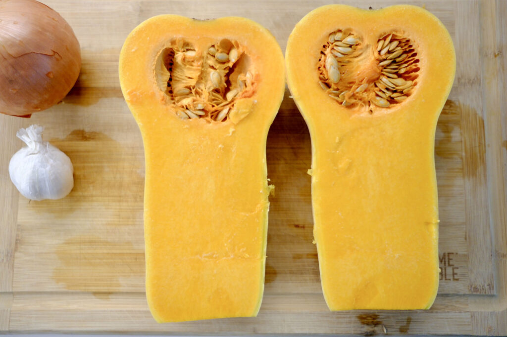 butternut squash cut in half and prepped for roasted butternut squash soup with garlic