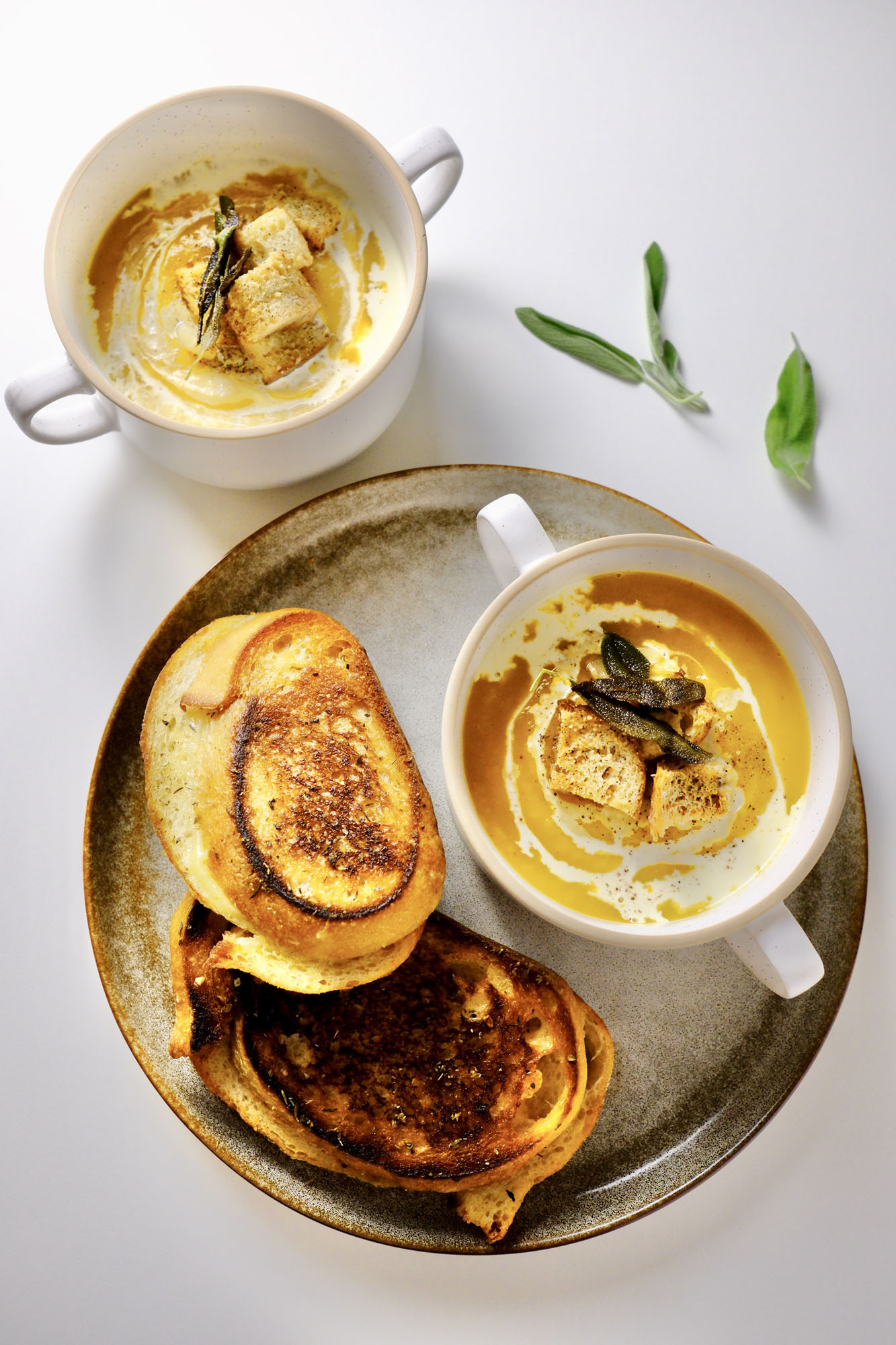 butternut squash soup with roasted garlic​ in a bowl on a plate