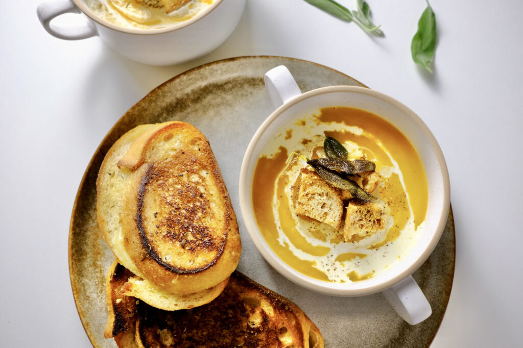 butternut squash soup with roasted garlic​ in a bowl