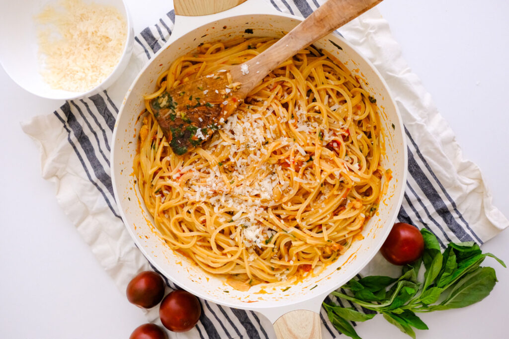 roasted garlic tomato pasta on a pan with tomatoes around it