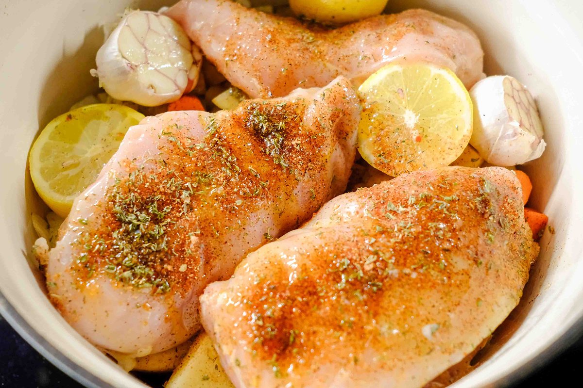 uncooked dutch oven with chicken breast and vegetables