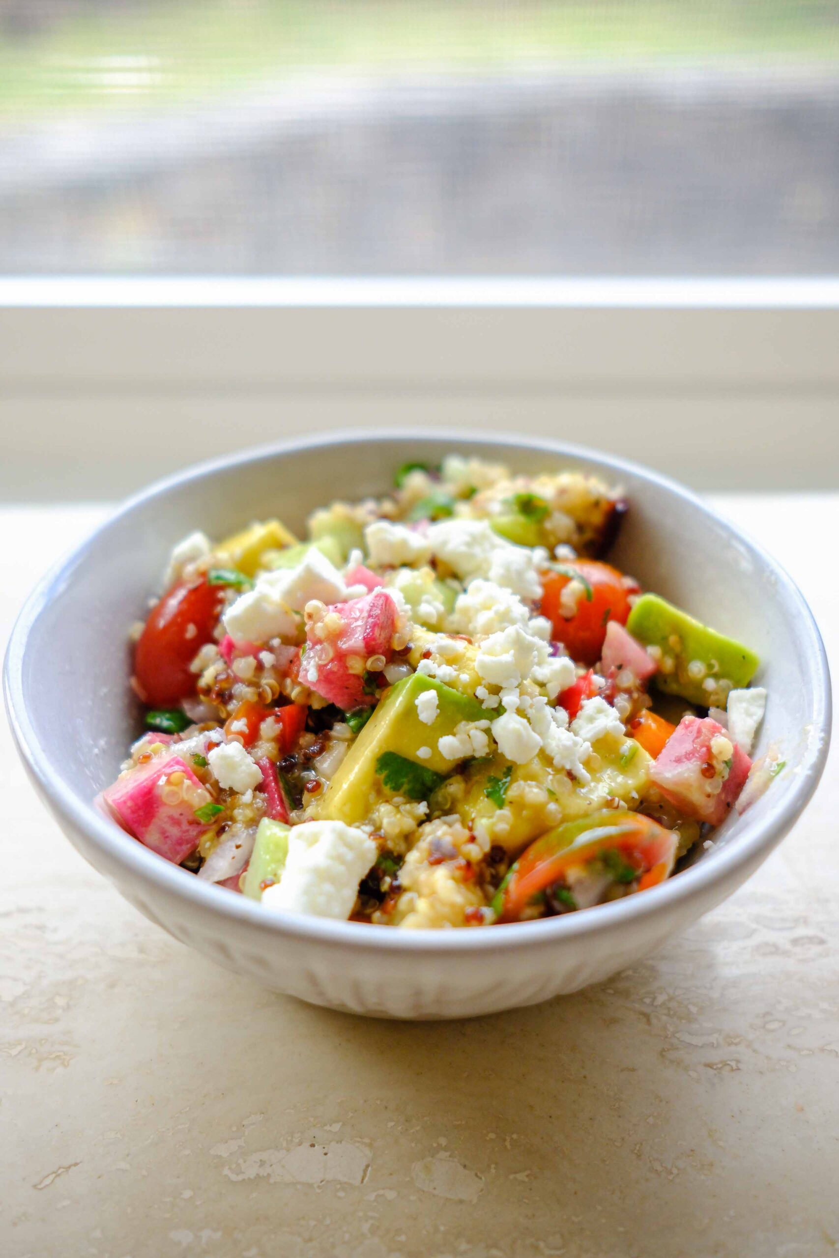 rainbow cucumber tomato quinoa salad in a bowl