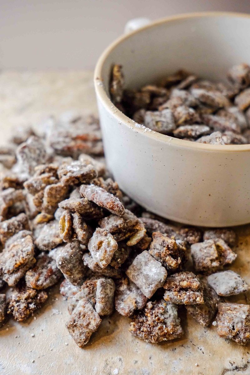 muddy buddies recipe​ spilling out of a bowl