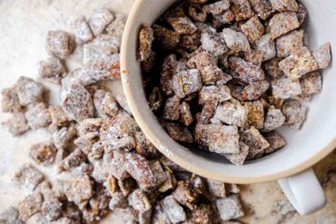 muddy buddy recipe, also known as puppy chow, spilling over a bowl