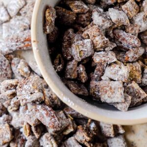 muddy buddy recipe, also known as puppy chow, spilling over a bowl