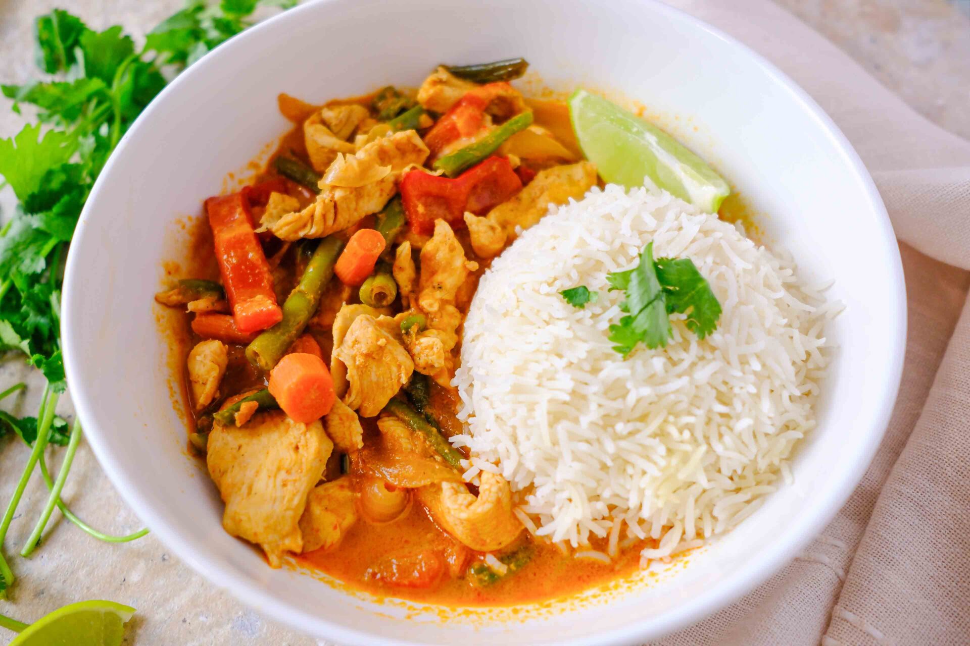 red thai chicken curry with rice and cilantro
